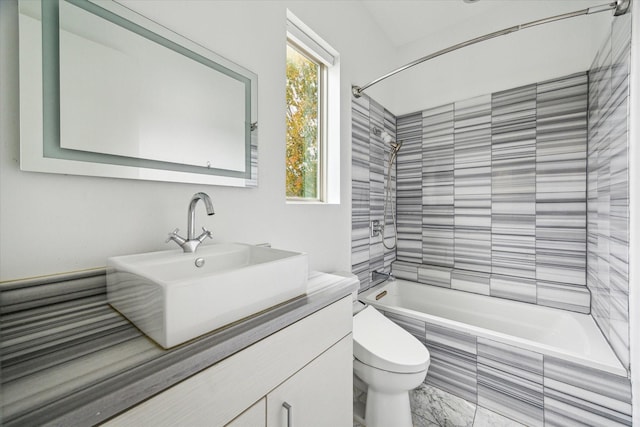 full bathroom featuring vanity, tiled shower / bath combo, and toilet