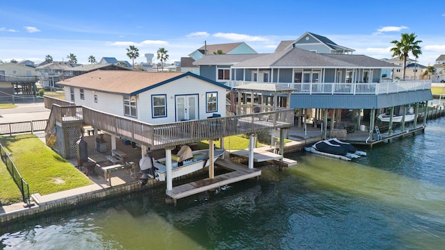 rear view of property with a deck with water view and a patio