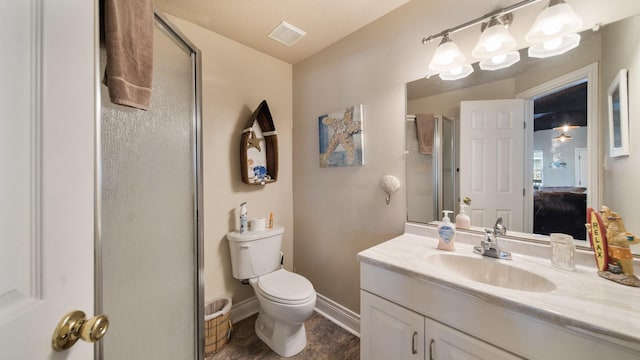 bathroom with a shower with door, vanity, and toilet