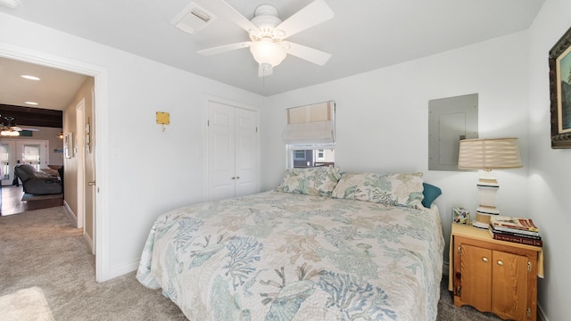 carpeted bedroom with electric panel, ceiling fan, a closet, and french doors