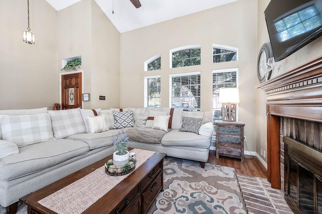 living room featuring hardwood / wood-style floors, ceiling fan, and high vaulted ceiling