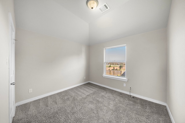 carpeted spare room with lofted ceiling