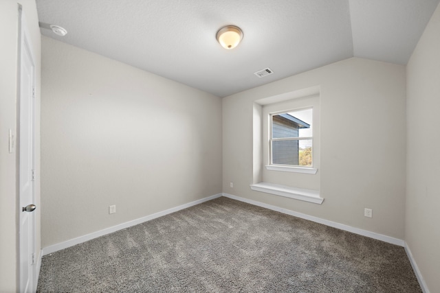 unfurnished room featuring carpet flooring and lofted ceiling