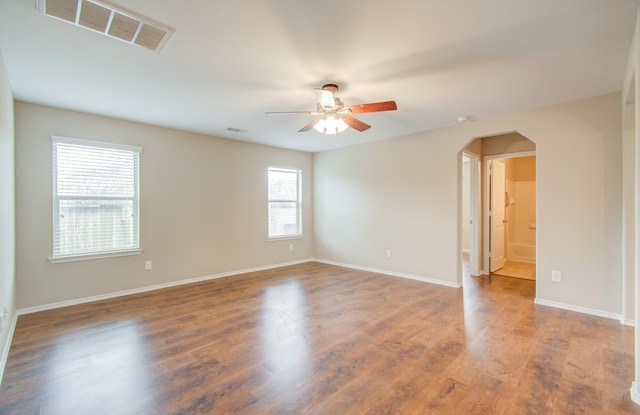 empty room with ceiling fan and dark hardwood / wood-style floors