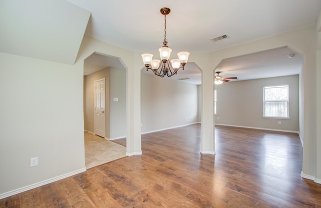 empty room featuring hardwood / wood-style floors and ceiling fan with notable chandelier