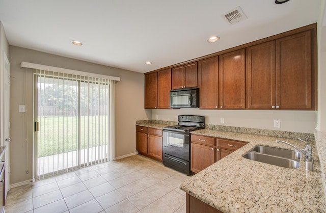 kitchen with black appliances, light stone counters, light tile patterned floors, and sink