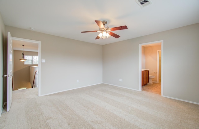 unfurnished bedroom with light carpet, ensuite bath, and ceiling fan