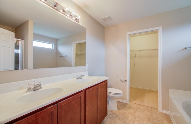 bathroom featuring tile patterned floors, a bathtub, toilet, and vanity