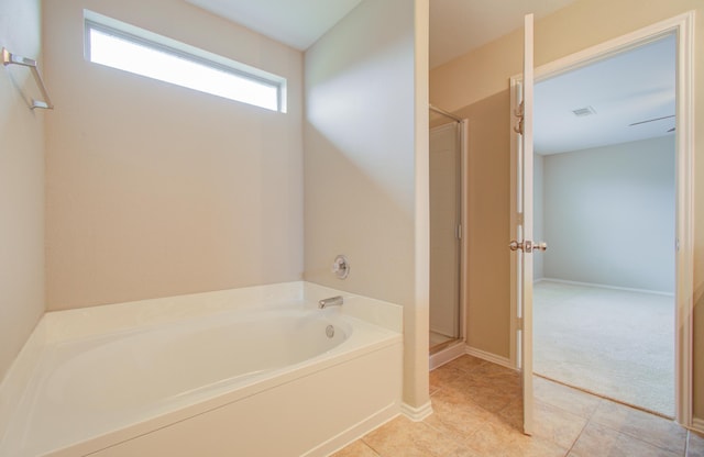 bathroom with tile patterned flooring and separate shower and tub