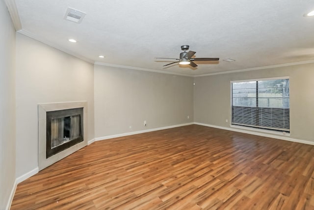 unfurnished living room featuring hardwood / wood-style flooring, ceiling fan, crown molding, and a textured ceiling