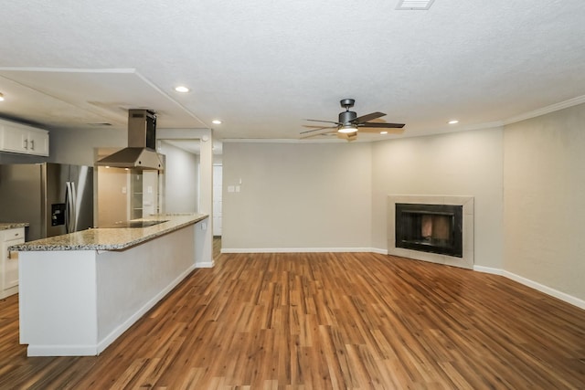 unfurnished living room with crown molding, a fireplace, wood-type flooring, and a textured ceiling