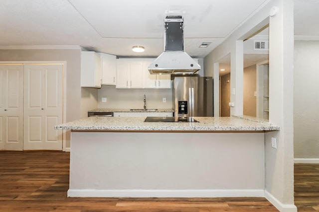 kitchen with kitchen peninsula, light stone countertops, hardwood / wood-style floors, white cabinets, and stainless steel fridge with ice dispenser