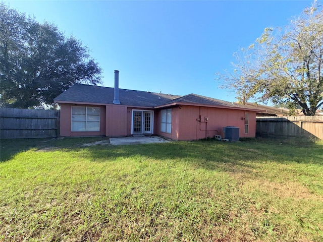 rear view of property with central air condition unit, a yard, and french doors