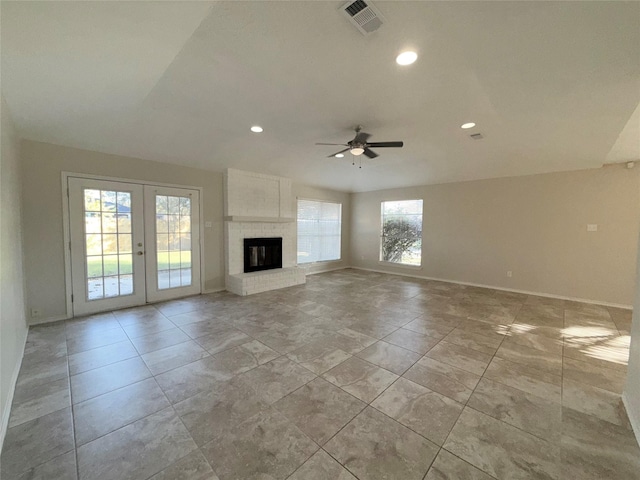 unfurnished living room with a fireplace, ceiling fan, and french doors