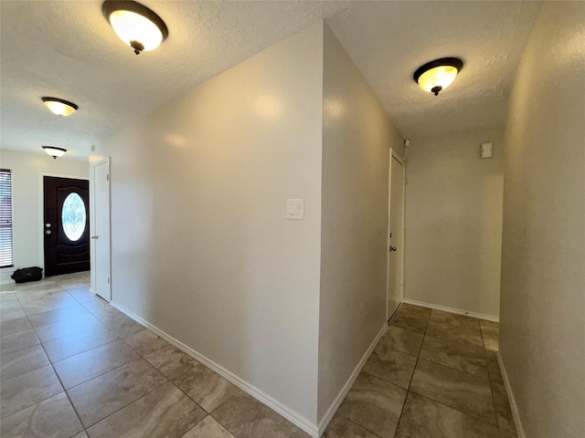 corridor with tile patterned floors and a textured ceiling