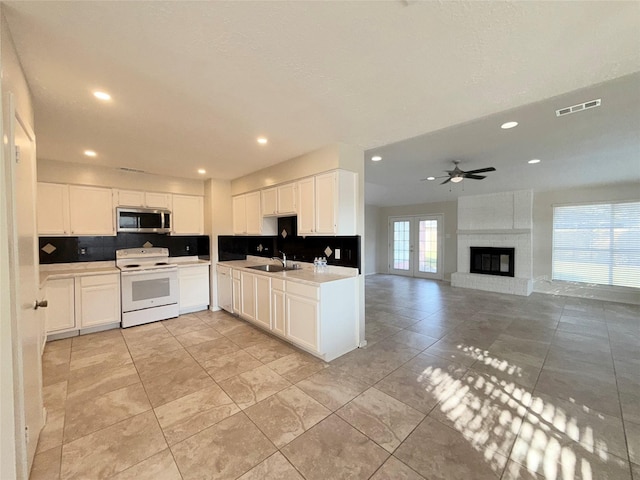 kitchen featuring white range with electric stovetop, ceiling fan, sink, and white cabinets