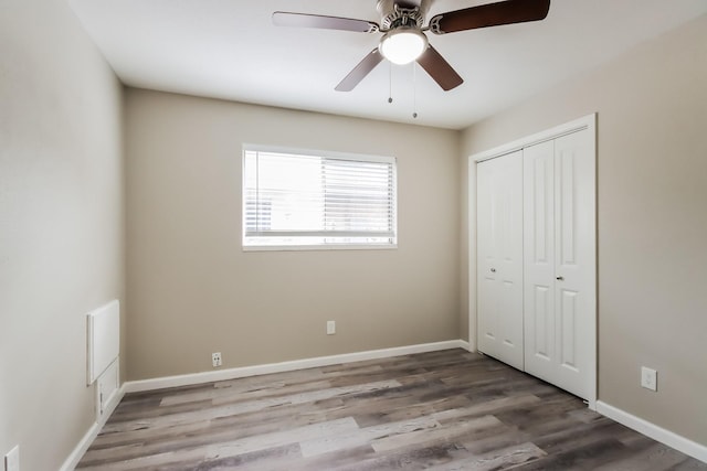 unfurnished bedroom featuring ceiling fan, a closet, and wood-type flooring