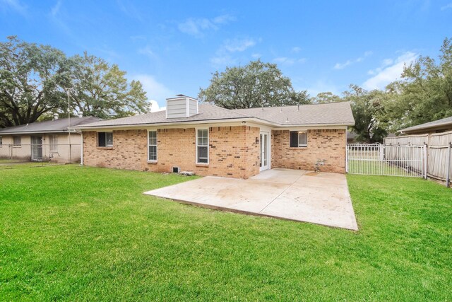 back of property with a patio area and a yard