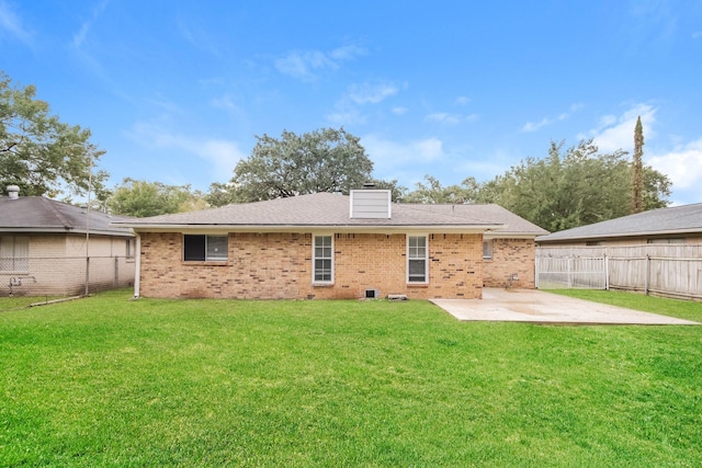 back of house featuring a lawn and a patio