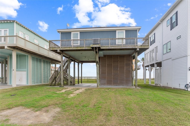 back of property featuring a carport, a yard, and a wooden deck