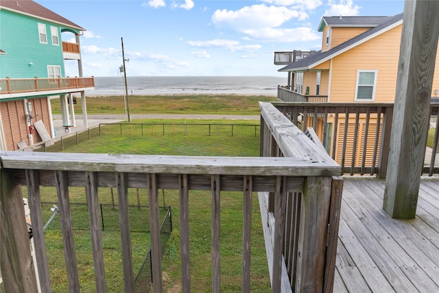 wooden terrace with a yard and a water view