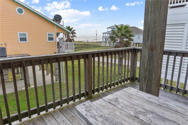 wooden deck with central air condition unit, a yard, and a water view