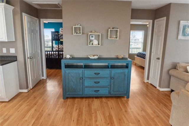 interior space with white cabinetry, light wood-type flooring, and blue cabinets