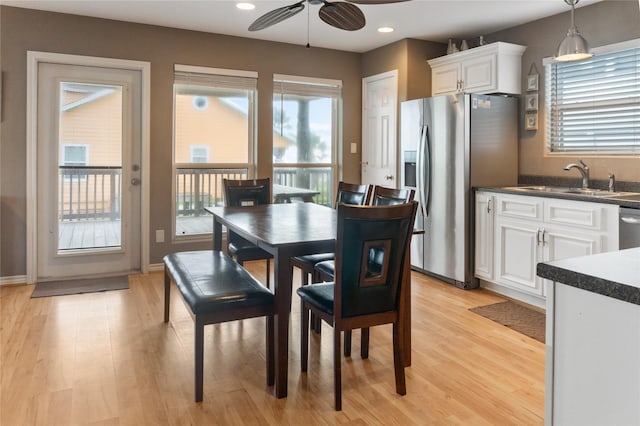 dining room featuring light wood-type flooring, ceiling fan, and sink