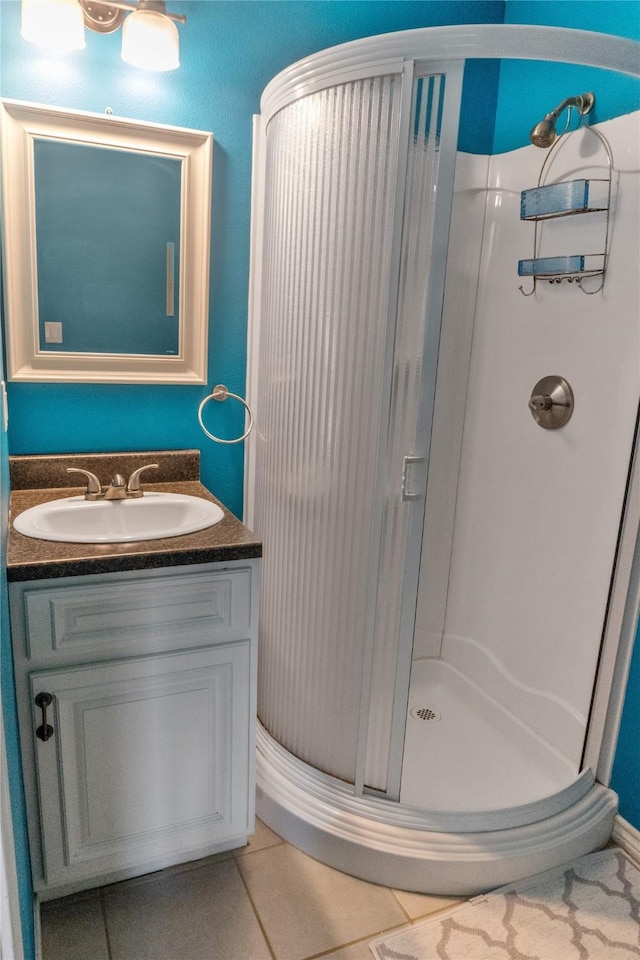 bathroom with tile patterned floors, vanity, and walk in shower