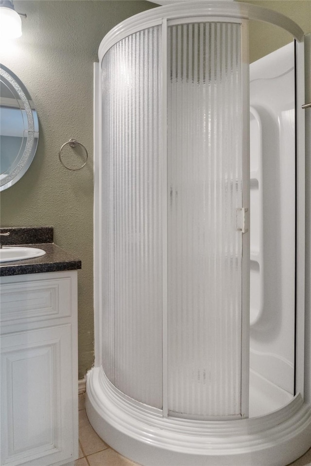 bathroom with tile patterned flooring, vanity, and a shower with shower door