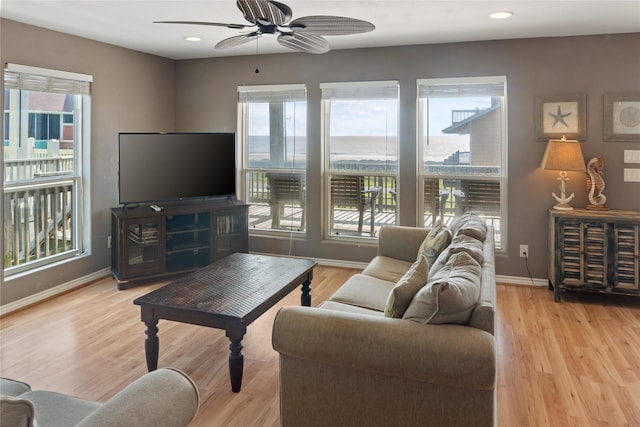 living room featuring a wealth of natural light, ceiling fan, and light hardwood / wood-style floors