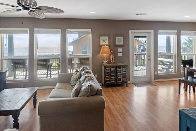 living room with light hardwood / wood-style flooring and ceiling fan