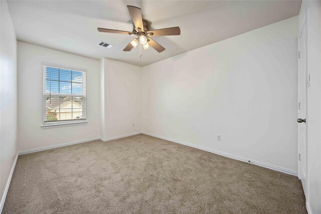 empty room featuring ceiling fan and carpet