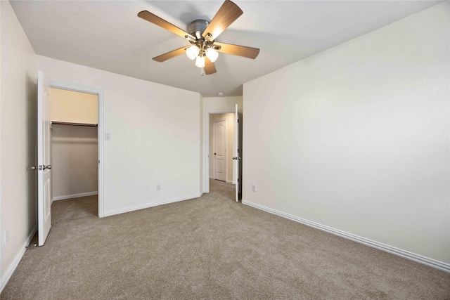 unfurnished bedroom with light carpet, a closet, a spacious closet, and ceiling fan