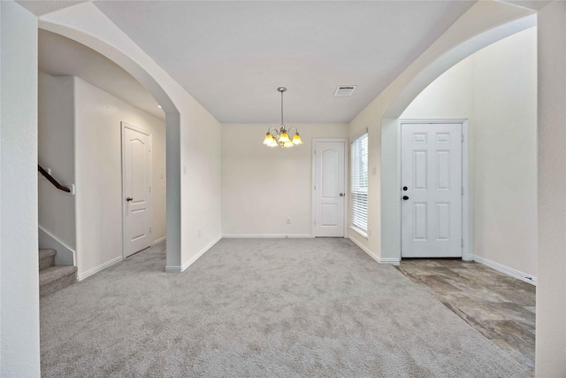 foyer featuring carpet flooring and a chandelier