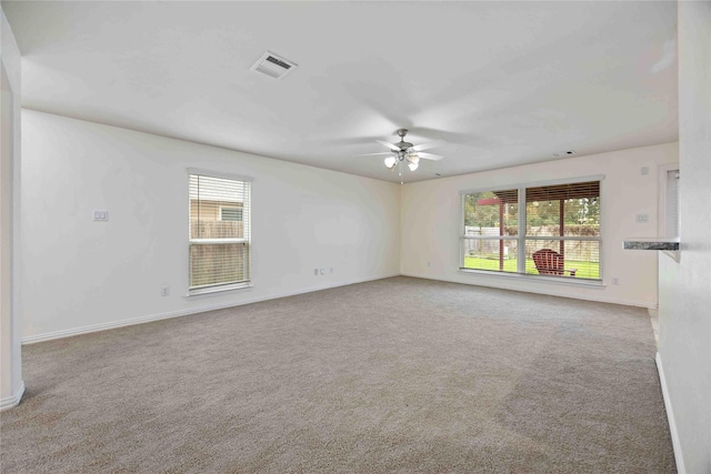 spare room featuring ceiling fan and carpet