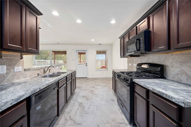 kitchen featuring light stone countertops, sink, tasteful backsplash, and black appliances