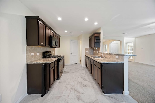 kitchen featuring black gas range, decorative backsplash, sink, and light carpet