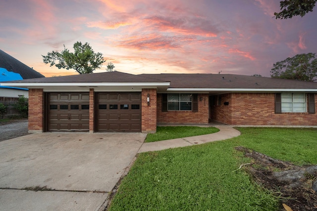 ranch-style house with a yard and a garage