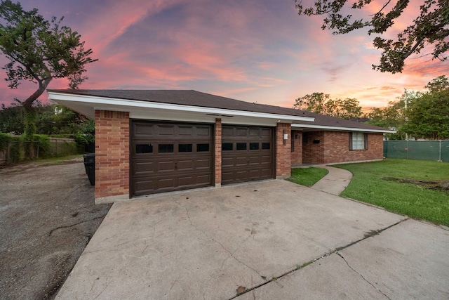 single story home featuring a yard and a garage