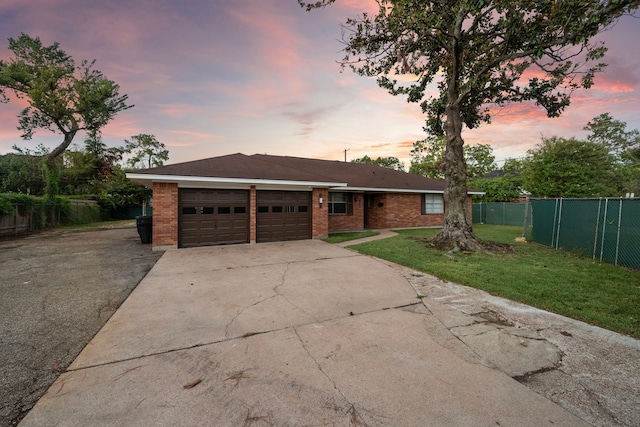 single story home featuring a garage and a yard