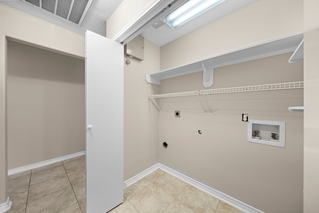 washroom with electric dryer hookup, hookup for a gas dryer, light tile patterned floors, and hookup for a washing machine