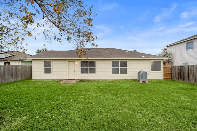 rear view of property with a yard and central AC unit