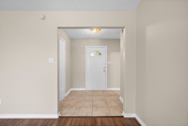 foyer entrance featuring a textured ceiling and light hardwood / wood-style flooring