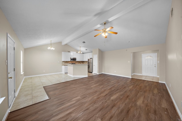 unfurnished living room with light hardwood / wood-style flooring, lofted ceiling with beams, and ceiling fan with notable chandelier