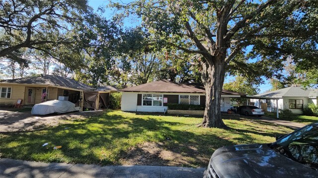 ranch-style home with a carport and a front lawn