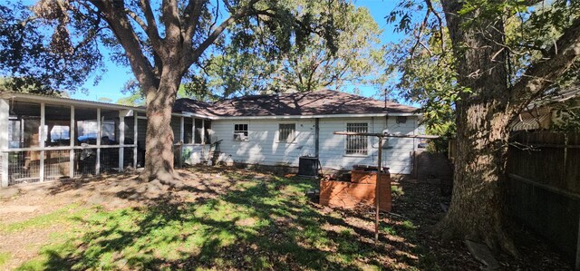 rear view of property with a sunroom and cooling unit