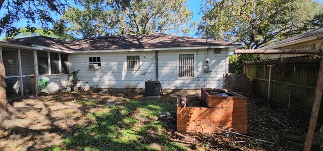 rear view of house featuring a sunroom and cooling unit