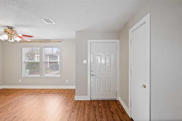 entryway featuring hardwood / wood-style flooring, ceiling fan, and a textured ceiling