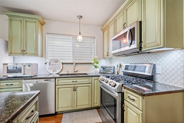 kitchen featuring decorative backsplash, appliances with stainless steel finishes, decorative light fixtures, and sink